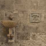 Sul muro esterno balza all'occhio un'acquasantiera singolare, con un "moro" che sorregge un bacile